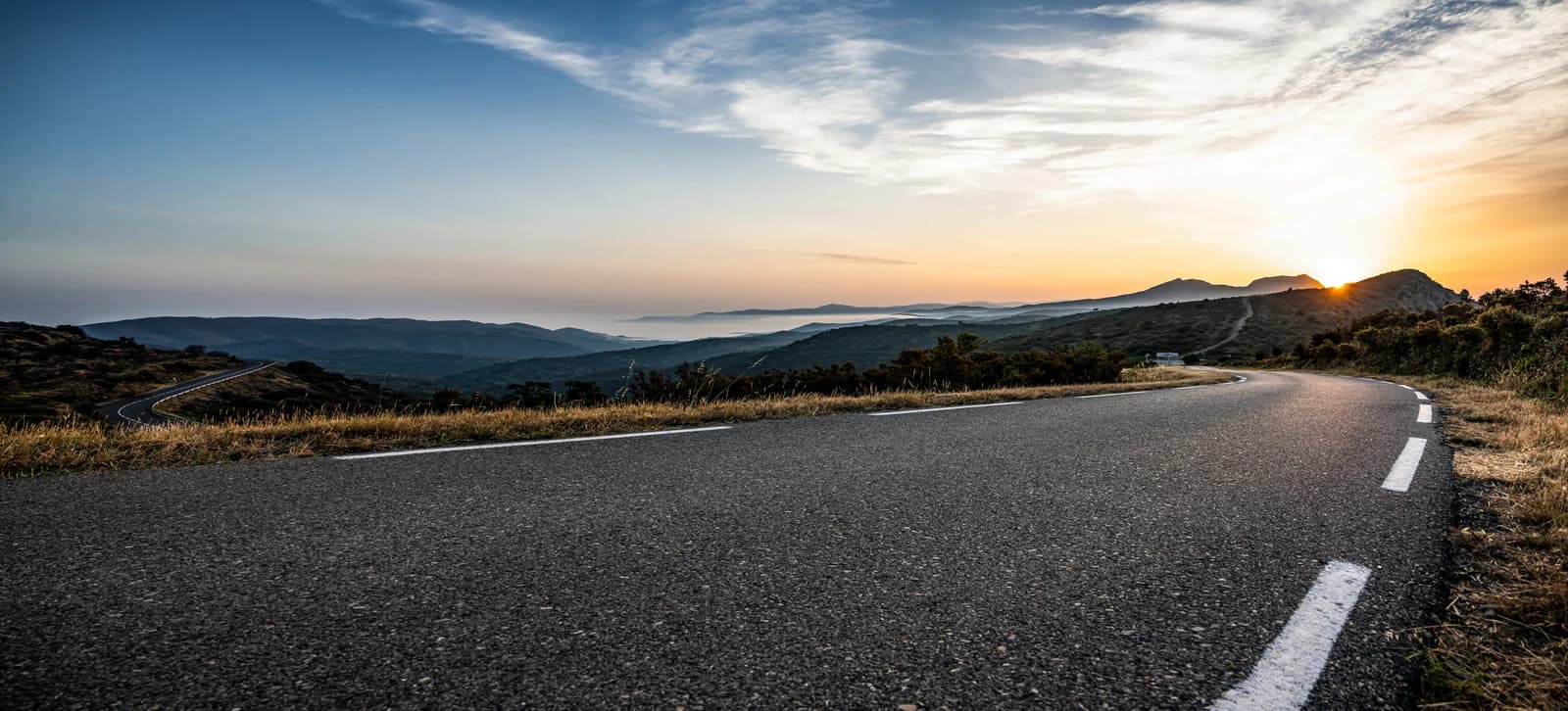 Winding road through mountain scenery at sunrise