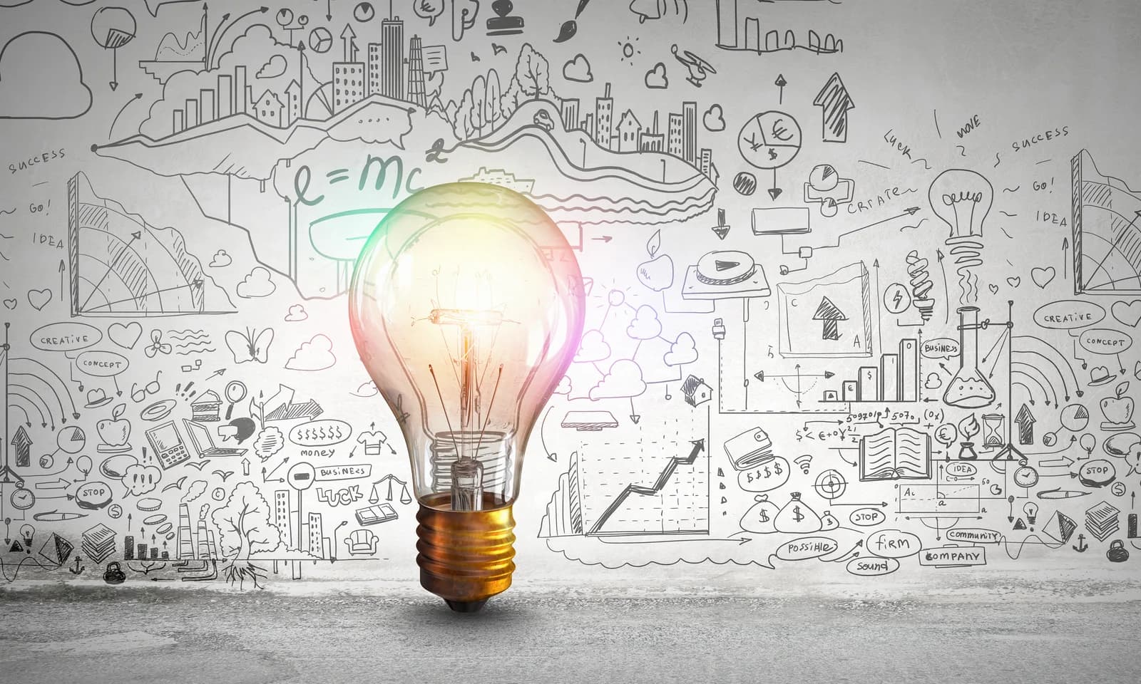Glowing light bulb surrounded by sketches of business ideas and opportunities